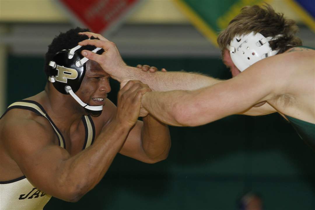 Perrysburg-wrestler-Micah-Carter-left-fights-off-the-attack-of-Cody-Thompson-of-Madison-Comprehensive