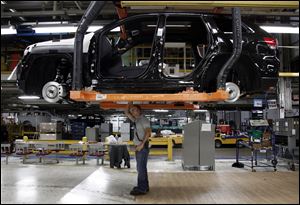 Jeff Caldwell, 29, right, a chassis assembly line supervisor, checks a vehicle on the assembly line at the Chrysler Jefferson North Assembly plant in Detroit.