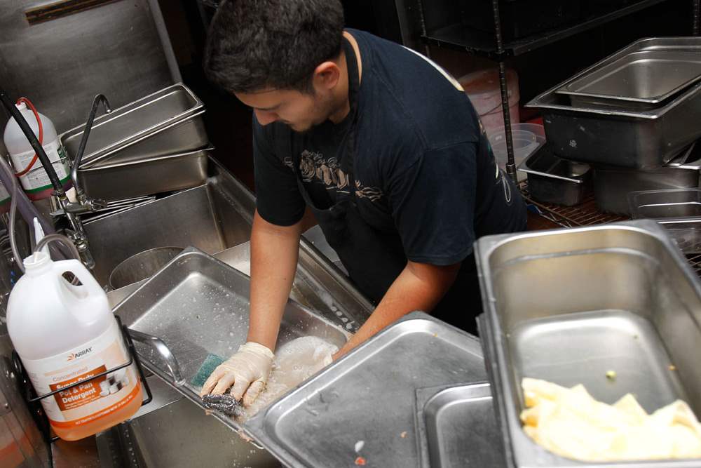 Antonio-Vasquez-cleans-dishes-in-the-kitchen-of-El-Vaquero