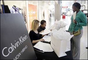 Shantel Howard, 29, of Miami, right, makes an appointment for a job interview with Calvin Klein employee Melina Mikhalices, left, after submitting her resume during a job fair at Dolphin Mall in Miami. Such interviews may one day be conducted by robots.