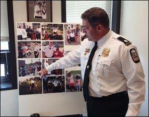 Commander Gary Cameron of the Columbus Division of Police points to pictures of officers who have participated in an annual anti-crime program today in Columbus. Police released statistics from the program, which has been criticized by protesters following two fatal shootings by officers. 