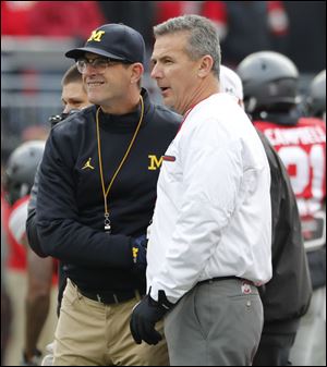Michigan coach Jim Harbaugh, left, and Ohio State coach Urban Meyer not only have a rivalry on the field but also battle over the Buckeye State's top recruits.