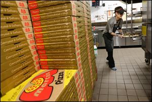 Shift manager Becky Smith puts a pizza in the oven at Marco's Pizza at the Anthony Wayne Trail and South Avenue. The Toledo-based chain has earned multiple honors.
