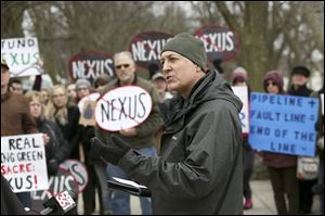 Andrew Kear, an associate professor with Bowling Green State University, center, calls on Nexus Gas Transmission (NEXUS) to reroute their proposed new pipeline at a press conference Wednesday, February 8, 2017, at Farnsworth Metropark near Whitehouse.