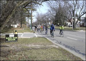Bicycles proceed southward on Secor Road approaching Darlington Road Saturday during a bike ride organized by the Save Our Secor group. The Ottawa Hills Village Council took no action Monday on the proposed reconstructing of Secor into a five-lane road.