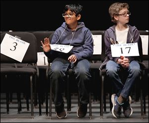 Srivatsav Vuppala, 11, of Perrysburg Junior High, waves to his family after winning the Northwest Ohio Championship Spelling Bee at Owens Community College in Perrysburg Township. To his right is Jimmy Kleshinski, who took second.