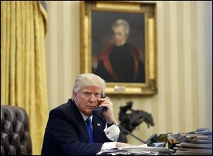 President Donald Trump on the telephone in the Oval Office of the White House in Washington. 