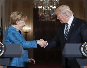 President Donald Trump and German Chancellor Angela Merkel shake hands following their joint news conference Friday at the White House.