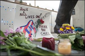 Flowers and well wishes are left below a statue of singer and musician Chuck Berry in University City, Mo.