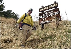Lefthand Fire District Chief Steve Lynn walks back to get supplies as crews battle the Sunshine Fire in the Sunshine canyon area of Boulder, Colo. on Sunday.