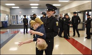 Former Blade reporter and Cadet Taylor Dungjen apprehends her son, Milan, before the 63rd Toledo Police Academy graduation ceremony at Bowsher High School.