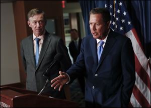 Ohio Gov. John Kasich, right, joined by Colorado Gov. John Hickenlooper, speaks during a news conference at the National Press Club in Washington on Tuesday.