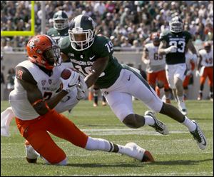 Bowling Green's Datrin Guyton makes a long catch under pressure from  Michigan State University defender during a game last year. Guyton has been charged with robbery and may face further charges stemming from a May incident.