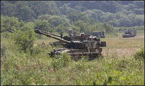 South Korean army soldiers take positions with their K-55 self-propelled howitzers during a military exercise in Paju, South Korea, near the border with North Korea on Monday.