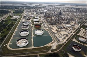 Storage tanks in retention ponds are surrounded by water left behind by Tropical Storm Harvey at ExxonMobil’s refinery in Baytown, Texas. Restarts at refineries are taking time.