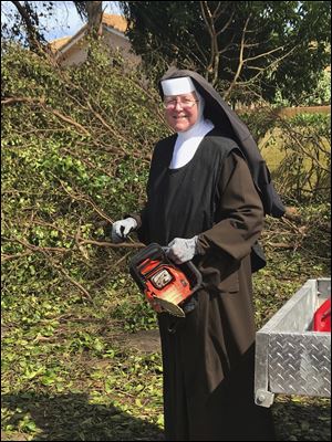 Sister Margaret Ann holds a chain saw near. Police said the nun was cutting trees to clear the roadways around Archbishop Coleman Carrol High School in the aftermath of Hurricane Irma.