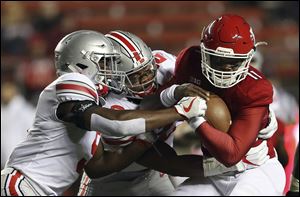 Ohio State linebacker Baron Browning, left, and defensive end Chase Young, center, team up to tackle Rutgers quarterback Johnathan Lewis during last season's 56-0 Buckeyes win.