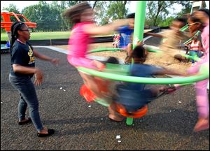 Anestie Brazzel of Toledo pushes other kids around on a spinning ride at Swan Creek Metropark in Toledo.