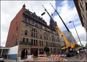 Workers remove a piece of the Pythian Castle Friday May 26, 2017 in Toledo. Developer Dave Ball acquired the castle at Jefferson Avenue and Ontario Street from the Lucas County Land Bank in November.