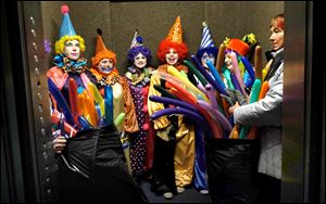 Clowns ride the elevator in the Edison Building down to the first floor for the bell ceremony before the start of the 29th annual Blade Holiday Parade in Downtown Toledo.