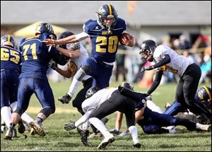 Whiteford running back Logan Murphy hurdles Clarkston Everest’s Giovanni Mastromatteo on Saturday in Ottawa Lake, Mich. Murphy had 173 yards rushing and two touchdowns.