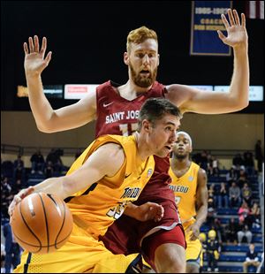 Toledo forward Nate Navigato drives past  St. Joseph's forward Anthony Longpre' Saturday at Savage Arena. Navigato scored 22 points to help the Rockets beat the Hawks, 98-87.
