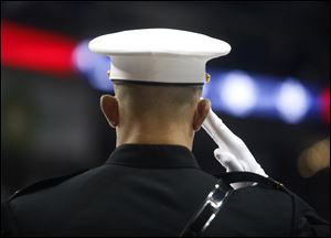 A Marine salutes during a pregame event honoring the armed forces for Veterans Day before Saturday's game between the Toledo Walleye and Wheeling Nailers at the Huntington Center in Toledo.