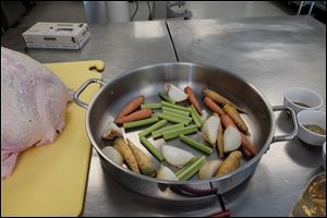 Carrots, onions, and celery go in the bottom of the roasting pan.
