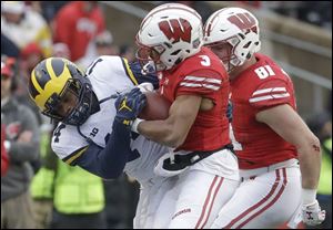 Wisconsin's Kendric Pryor catches a pass in front of Michigan's Josh Metellus during the first half. Wisconsin went on to win 24-10.