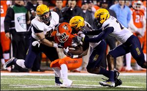 Bowling Green State University running back Josh Cleveland is stopped by a host of Toledo defenders last season. The Rockets have won the past eight games between the rivals.