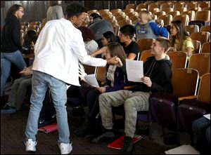 Seniors Da'von Brown, standing, is encouraged by Frankie Veres as they prepare their scripts for the Fallen Heroes Memorial Program at Waite High School in Toledo. 