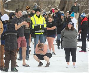 Participants in the annual Polar Bear Plunge try to stay warm prior to the plunge Monday in Waterville, Ohio.
