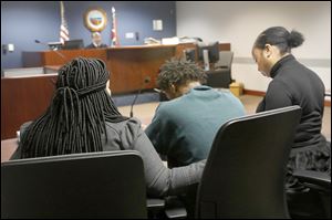 Demetrius Wimberly, 14, center, is comforted as he is arraigned on the charge of murder Dec. 27, 2017, at Lucas County Juvenile Court in Toledo. Wimberly is one of four boys charged in the death of Marquise Byrd, 22. 