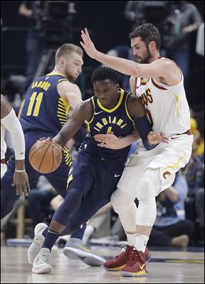 Indiana Pacers' Victor Oladipo is defended by Cleveland Cavaliers' Kevin Love.