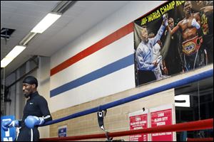 A poster with a photograph of Robert Easter, Jr., after he won the IBF lightweight championship hangs overhead as he takes a moment during a workout at Glass City Boxing Gym in Toledo. 