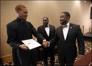 Scholarship recipient Keion Devalt II, left, receives his plaque from Nathaniel Young, left, and chapter president Rev. Brandon Tucker, right, during the annual scholarship breakfast hosted by the local UT chapter of Alpha Phi Alpha at The Pinnacle.