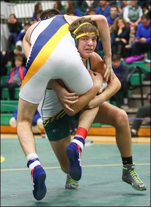 Oregon Clay's Garret Anderson grabs the leg of Achbold's Gavin Grime in the 145 pound championship match during the Maumee Bay Classic wrestling tournament earlier this year.
