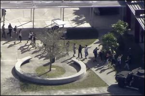 In this frame grab from video provided by WPLG-TV, students from the Marjory Stoneman Douglas High School in Parkland, Fla., evacuate the school following a shooting there on Wednesday.