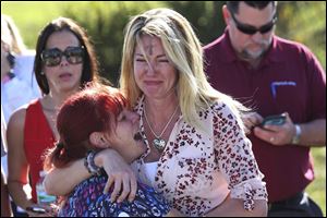 Parents wait for news after a reports of a shooting at Marjory Stoneman Douglas High School in Parkland, Fla., on Wednesday, Feb. 14, 2018.