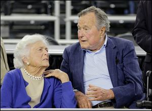 In this March 29, 2015, file photo, former President George H.W. Bush and his wife Barbara Bush, left, speak before a college basketball game in Houston. A family spokesman said Sunday that the former first lady Barbara Bush is in 