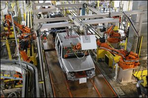 Robots install windows at the Toledo Jeep Assembly Complex Many fear the robots will displace human workers.. 