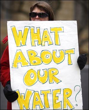 In this file photo, Sandra Frank holds a sign during a picket by the Advocates for a Clean Lake Erie outside of the federal courthouse in Toledo.