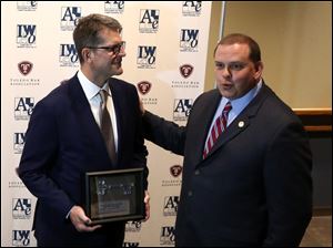 Michigan head coach Jim Harbaugh, left, is presented the key to the city by Mayor Wade Kapszukiewicz ahead of the ABLE Access to Justice awards dinner at the SeaGate Centre.