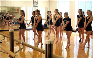 The St. Ursula Academy Dance Team is reflected in the mirror during practice.
