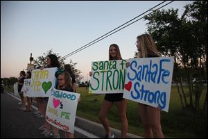 Hannah Cook, 16, second from right, of Kingwood, Texas, drove down to stand in front of Santa Fe High School with her fellow high school dance teammates to show support for the students returning to class.