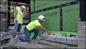 SASCO Masonry workers Randy Fowler, left, and Yancy Richmond install cement blocks and wall flashing during construction of the new Savage & Associates headquarters.