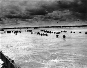 U.S. reinforcements wade through the surf as they land at Normandy in the days following the Allies' D-Day invasion of France in June, 1944.