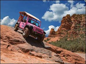 A Pink Jeep takes to the rugged terrain in Sedona, Ariz.
