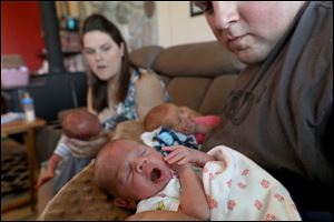 Logan yawns after being fed. Katie and Kyle Segrist bottle feed their triplets in their Delta, Ohio home.