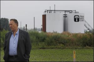 John Chandler, Summerfield Township Supervisor, stands near a conventional oil-producing well owned by Trendwell Energy Corp. off Ida Center Road in Ida Township, located in Monroe County, Mich.